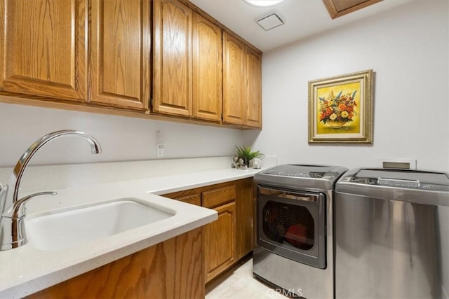 laundry area with cabinet space, a sink, and washing machine and clothes dryer