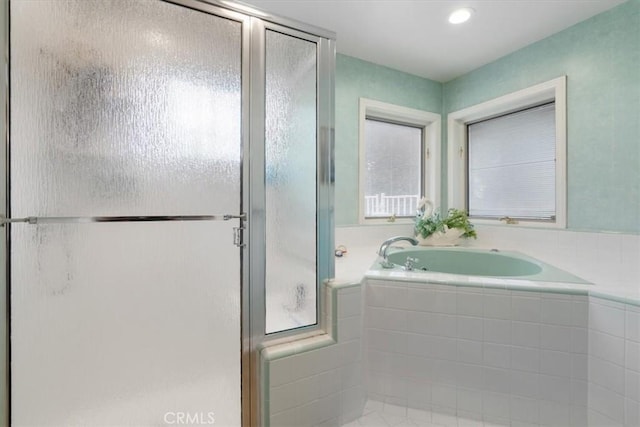 full bathroom with a shower stall and a bath