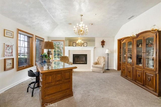 carpeted office with a chandelier, a fireplace with flush hearth, visible vents, baseboards, and vaulted ceiling