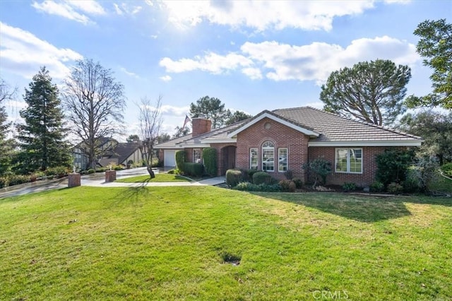 ranch-style home featuring brick siding, a chimney, and a front yard