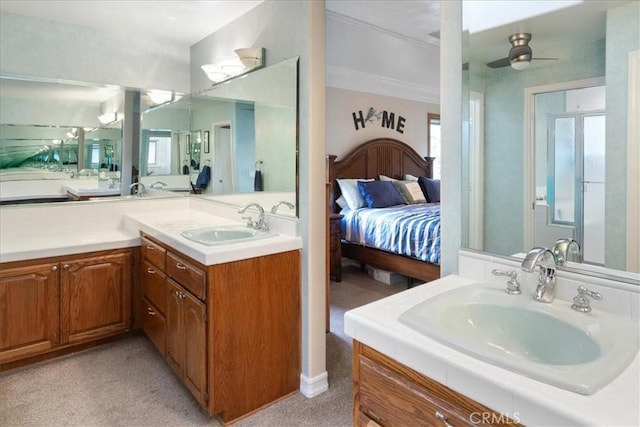 ensuite bathroom with connected bathroom, two vanities, and a sink