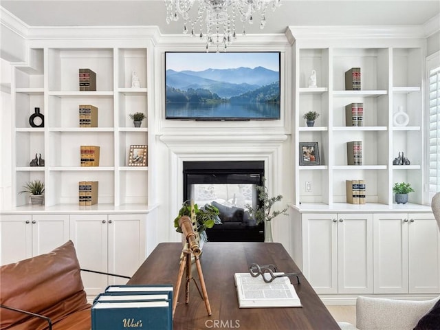 sitting room with a chandelier, ornamental molding, a multi sided fireplace, and built in features