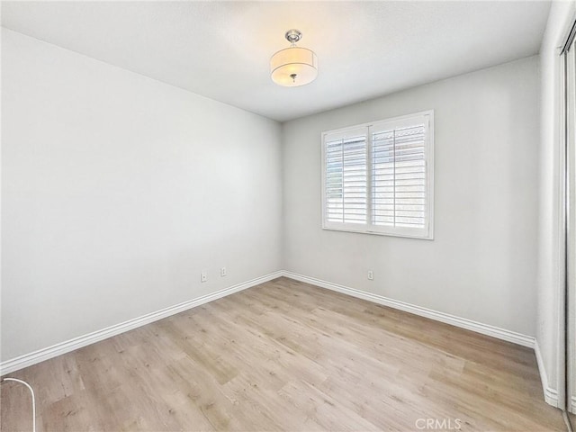 empty room with light wood-style flooring and baseboards