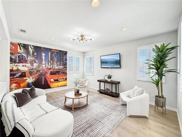 living area featuring light wood-type flooring, visible vents, and baseboards