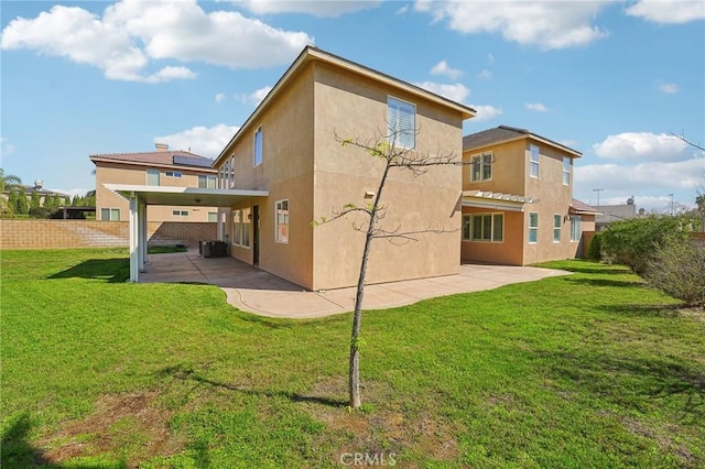 back of house with a lawn, a patio area, fence, and stucco siding