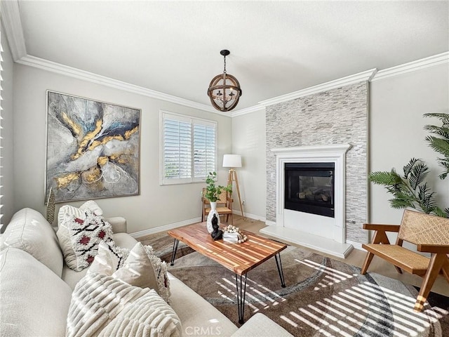 living area featuring a chandelier, wood finished floors, baseboards, a glass covered fireplace, and crown molding