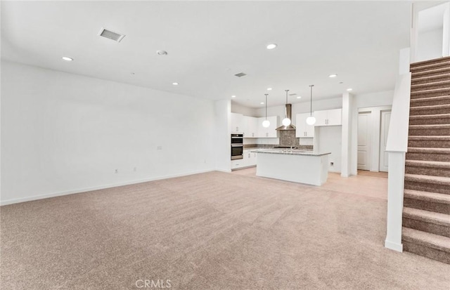 unfurnished living room featuring light carpet, stairs, visible vents, and recessed lighting