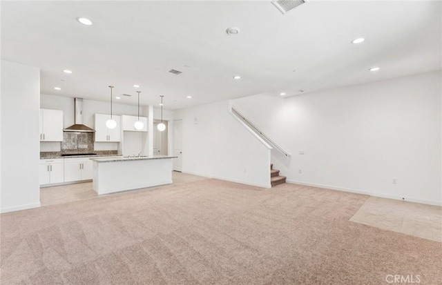 unfurnished living room featuring stairway, recessed lighting, visible vents, and light colored carpet