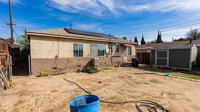 back of property featuring an outbuilding, crawl space, a fenced backyard, and a storage shed