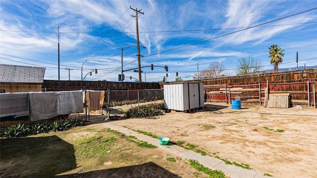 view of yard with an outbuilding, a fenced backyard, and a storage unit