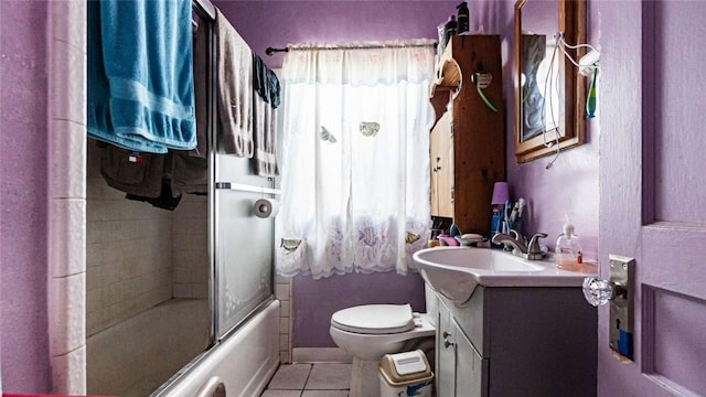 full bathroom with toilet, shower / bath combination with glass door, tile patterned flooring, and vanity