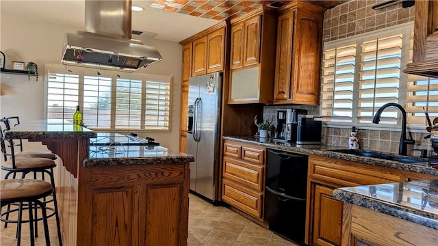 kitchen featuring island range hood, a breakfast bar, a sink, brown cabinets, and black appliances