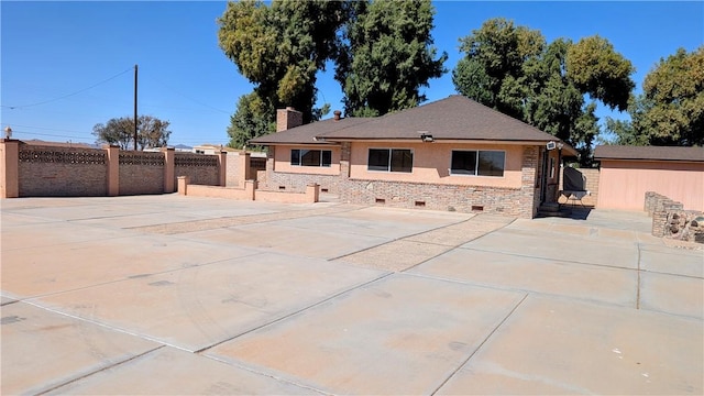 back of property with crawl space, a patio area, a chimney, and fence