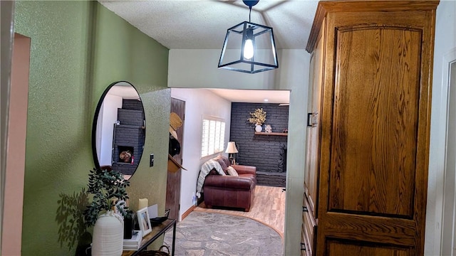 interior space featuring a textured wall, a textured ceiling, baseboards, and wood finished floors