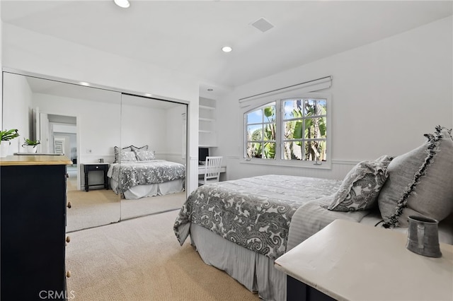 bedroom featuring a closet, recessed lighting, and light colored carpet