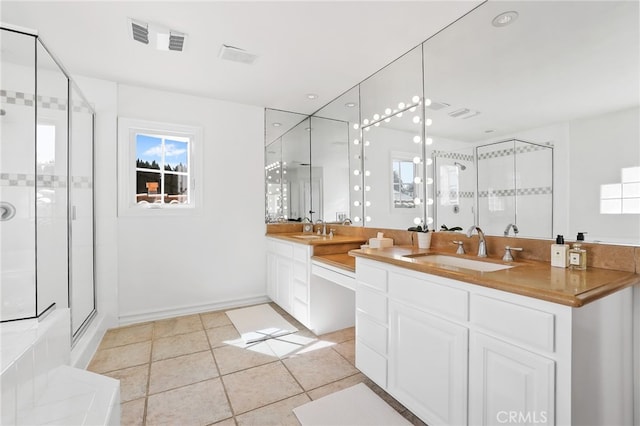 bathroom featuring a healthy amount of sunlight, a sink, and a shower stall