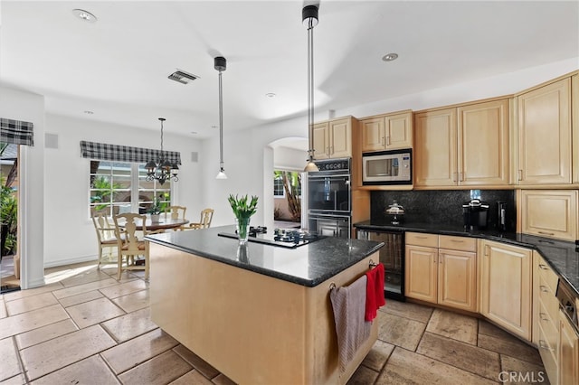 kitchen featuring a center island, pendant lighting, stone tile floors, tasteful backsplash, and black appliances