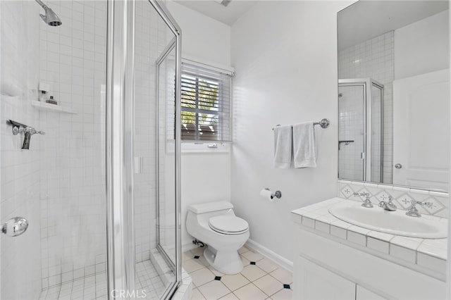 bathroom with a stall shower, vanity, toilet, and baseboards