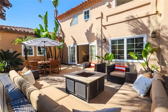 view of patio / terrace featuring outdoor dining space and an outdoor living space with a fire pit