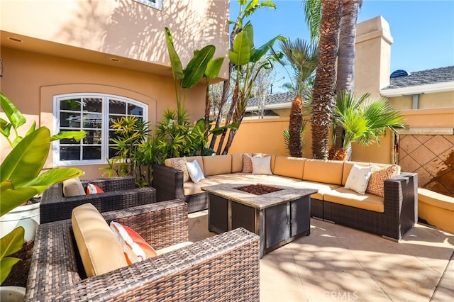 view of patio / terrace with an outdoor living space with a fire pit and fence