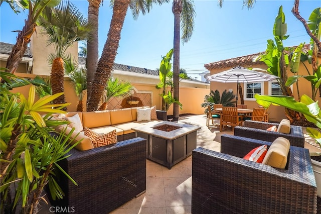 view of patio featuring outdoor dining area, an outdoor living space with a fire pit, and fence