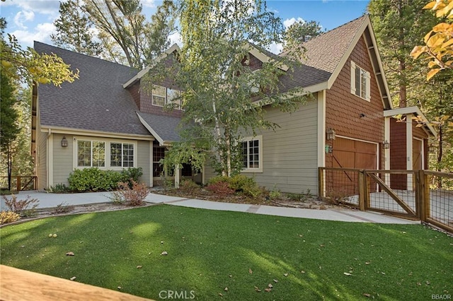 view of front of home featuring a front lawn, a shingled roof, and a gate