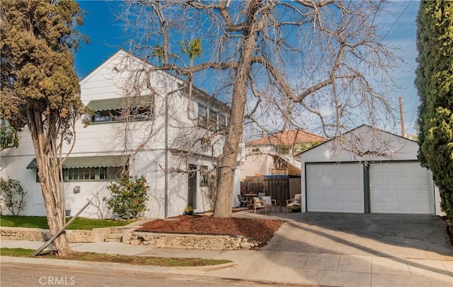 view of front of house with an outbuilding, a detached garage, and stucco siding