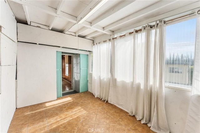 spare room featuring light tile patterned floors and a healthy amount of sunlight