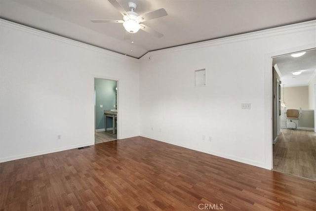 empty room with lofted ceiling, ceiling fan, ornamental molding, and wood finished floors