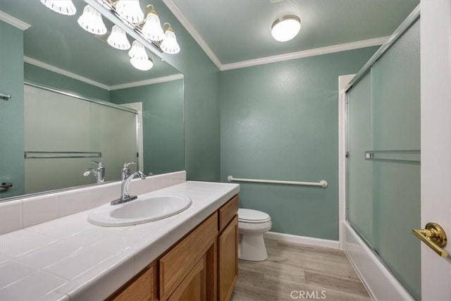 full bath featuring toilet, ornamental molding, combined bath / shower with glass door, vanity, and wood finished floors