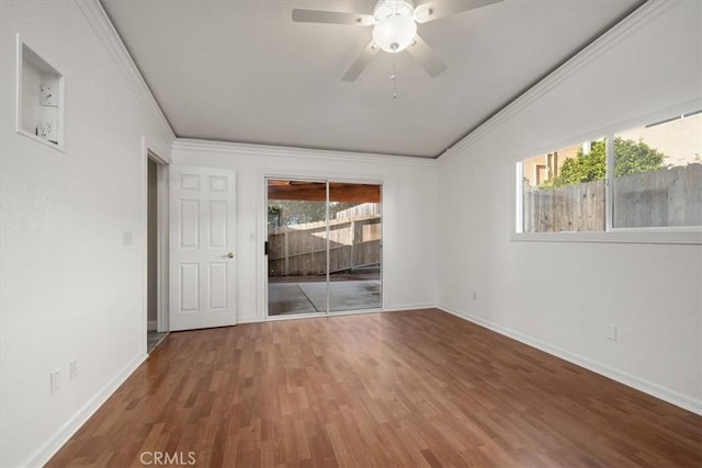 spare room featuring ceiling fan, crown molding, baseboards, and wood finished floors