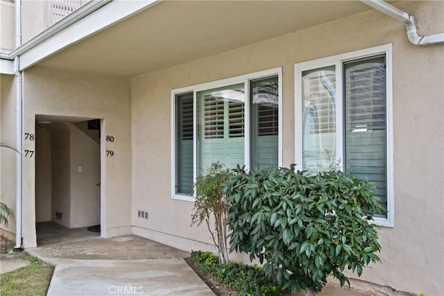 entrance to property featuring stucco siding