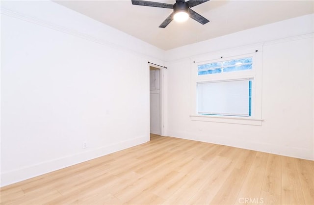 unfurnished room featuring ceiling fan, wood finished floors, and baseboards