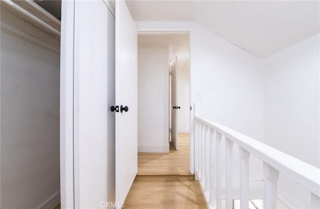 corridor featuring vaulted ceiling and light wood finished floors