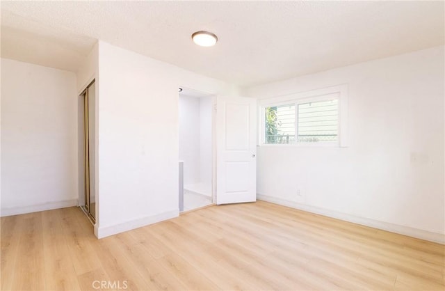 empty room with light wood-style floors and baseboards