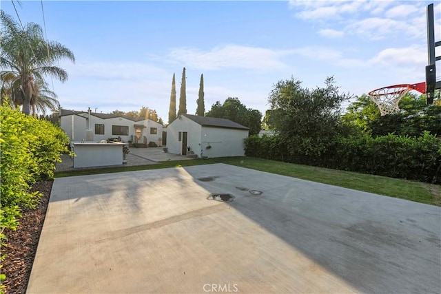 view of front of home with basketball court and a front yard