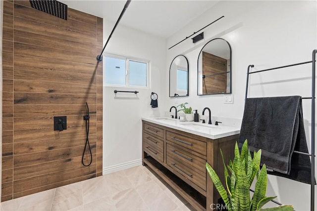 bathroom with a walk in shower, a sink, baseboards, and double vanity