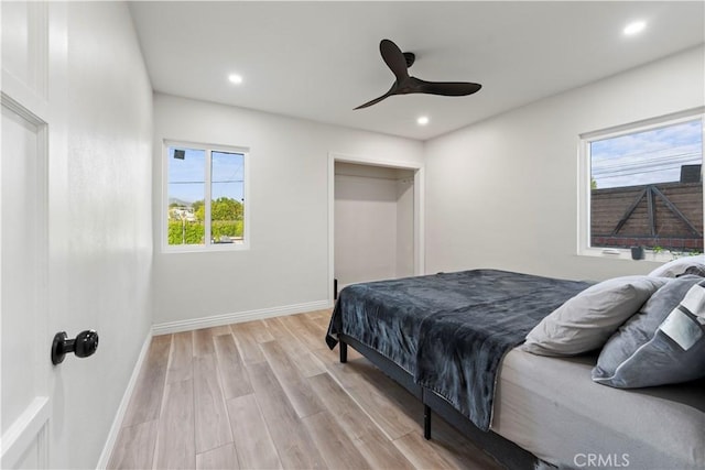 bedroom featuring baseboards, light wood-type flooring, a ceiling fan, and recessed lighting