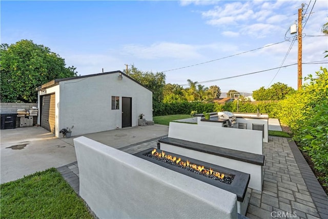 view of patio featuring a fire pit and an outdoor structure