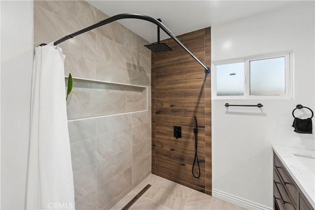 full bathroom with tiled shower and vanity