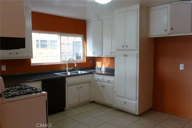 kitchen featuring dark countertops, white cabinets, a sink, and white gas range