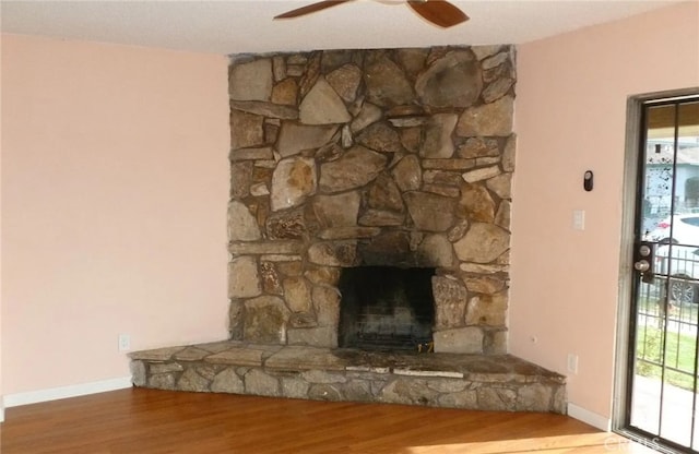 room details featuring ceiling fan, a fireplace, baseboards, and wood finished floors