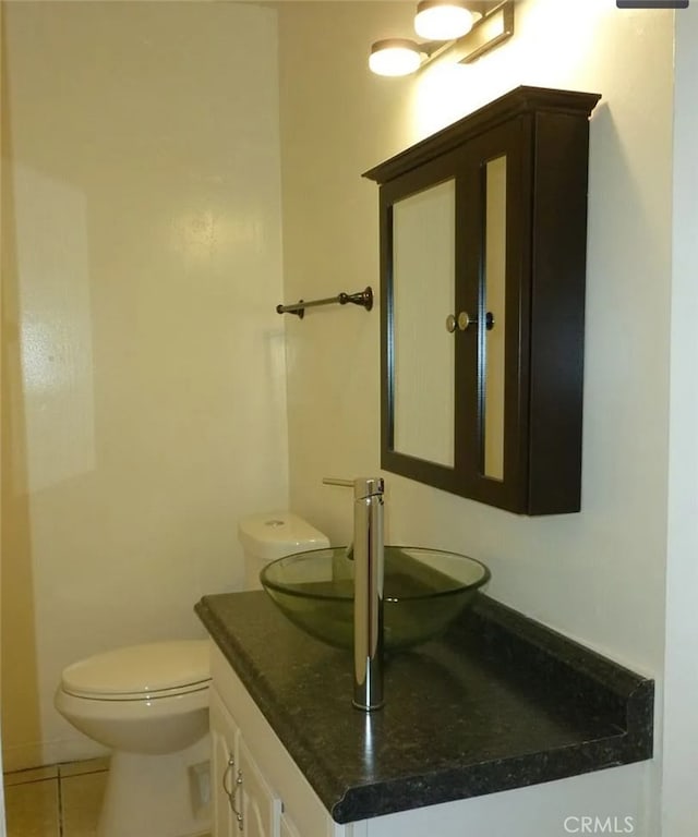 bathroom featuring tile patterned flooring, vanity, and toilet