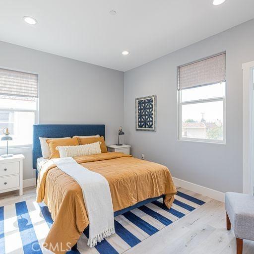 bedroom with light wood finished floors, baseboards, and recessed lighting