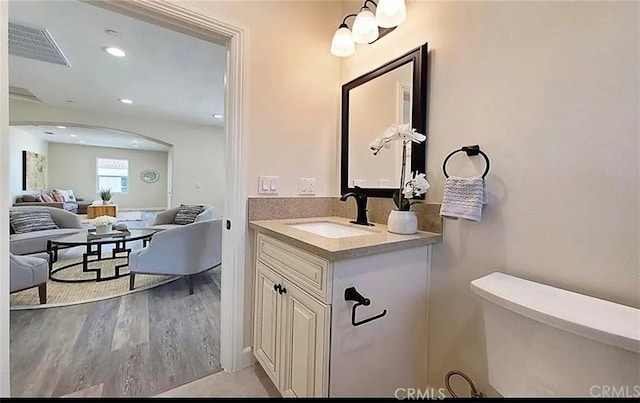 bathroom featuring recessed lighting, visible vents, toilet, vanity, and wood finished floors