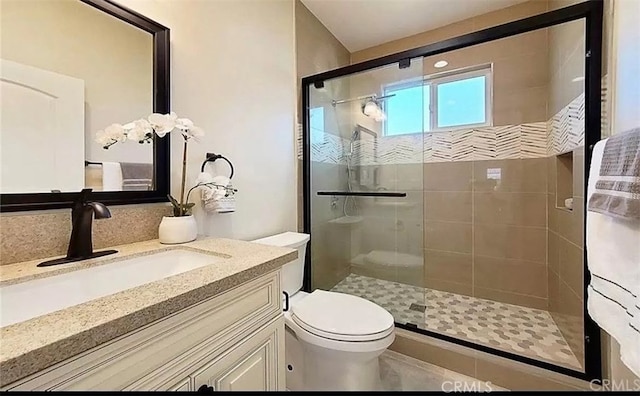 full bathroom with toilet, a shower stall, and vanity