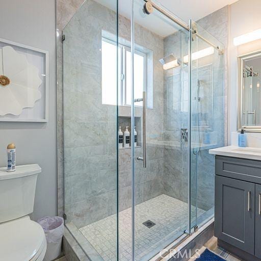 full bath with toilet, a shower stall, and vanity