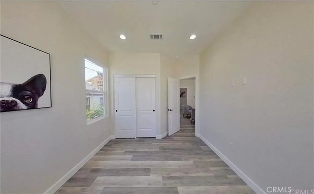 corridor featuring recessed lighting, visible vents, light wood-style flooring, and baseboards