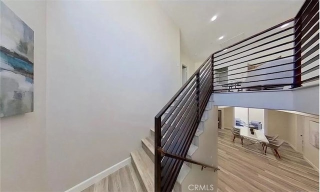 staircase featuring baseboards and wood finished floors