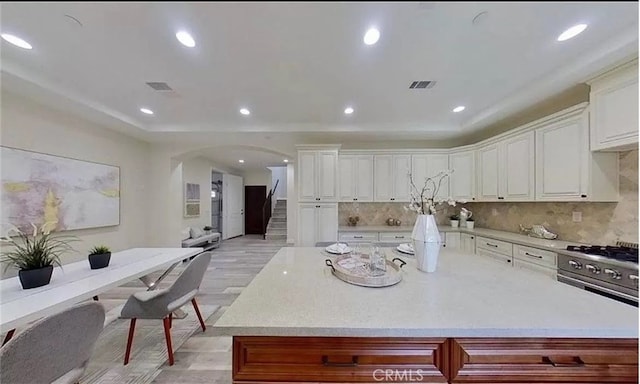 kitchen featuring arched walkways, recessed lighting, light countertops, visible vents, and white cabinetry